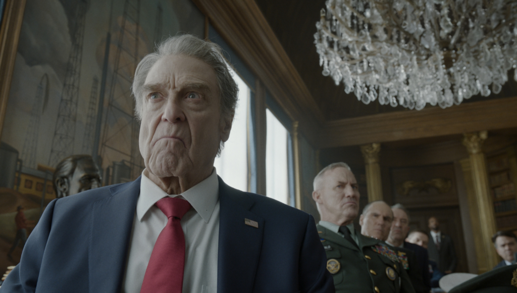 JOHN GOODMAN as President Compson and (behind) ROBERT JOHN BURKE as General Fitzgerald in Warner Bros. Pictures’ “DIGGER,”